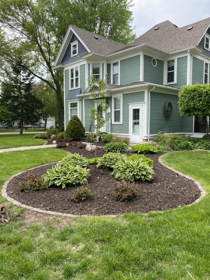 Red truck parked by a home with a garage, landscaped garden, and paved walkway.